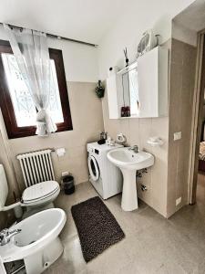 a white bathroom with a sink and a toilet at Casa9cento in Omegna