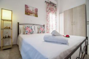 a bedroom with a large white bed with flowers on it at House of Flowers near beach in Ierápetra