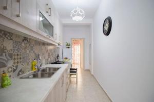 a kitchen with a sink and a clock on the wall at House of Flowers near beach in Ierápetra
