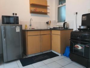 a kitchen with a refrigerator and a stove at Regional Homes Ke Racecourse Gardens in Nairobi