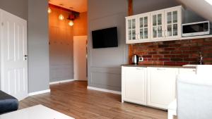 a kitchen with white cabinets and a brick wall at Vintageapartment in Sopot