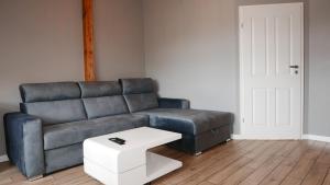 a living room with a leather couch and a white table at Vintageapartment in Sopot