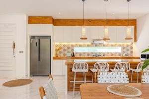 une cuisine avec une table et un réfrigérateur dans l'établissement Villa Vana, Sitara Villa Group, à Seminyak 33 autres photos