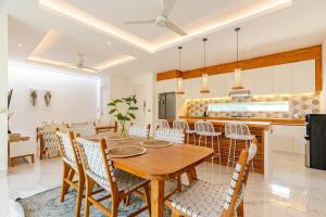 une cuisine et une salle à manger avec une table et des chaises en bois dans l'établissement Villa Vana, Sitara Villa Group, à Seminyak
