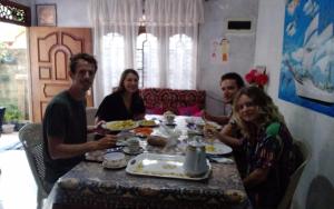 Un grupo de personas sentadas alrededor de una mesa comiendo comida en mirissa niraj guest, en Mirissa
