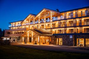 - un grand bâtiment en bois la nuit dans l'établissement Alpin Peaks, à Turracher Höhe