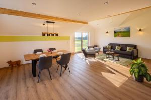 Una sala de estar con una mesa y sillas y un sofá. en Ferienwohnung Egg-Hof, en Bad Grönenbach