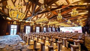 a large room with chairs and chandeliers and a screen at Mission Hills Resort Haikou in Haikou +66 photos