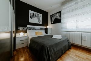a bedroom with a bed and two zebra prints on the wall at Logroño Premium Home in Logroño