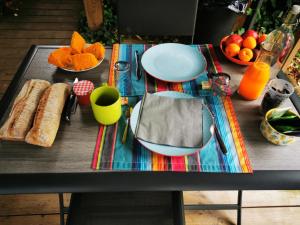 a table with plates of food and fruit on it at Villa Uhaïna Hossegor in Hossegor