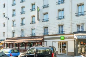 a white building with cars parked in front of it at ibis Styles Paris Eiffel Cambronne in Paris