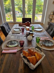 a wooden table with bread and plates of food on it at La Maison du Mont in Graignes