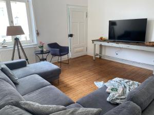 a living room with a couch and a flat screen tv at SweetLeopold1 in Bad Kreuznach