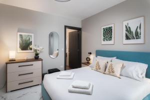 a white bedroom with a blue and white bed at Modern 2BR Cosy Apartment with Large Terrace - Close to Manoel Island & Tigne Shopping Mall in Sliema