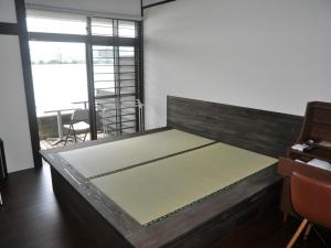 a large bed in a room with a large window at Riverside Hotel Karatsu Castle in Karatsu