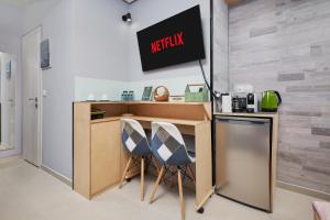 una cucina con due sedie e un bancone con un cartello Reactix di VM CENTRAL STUDIO a Heraklion