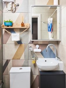 un bagno con lavandino e specchio di VM CENTRAL STUDIO a Heraklion Altre 37 foto