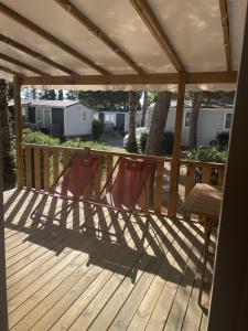 a wooden deck with a pergola and a bench at St Cyprien Mobil home 6 personnes Linge inclus in Saint-Cyprien