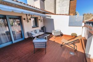 un patio con sillas y un sofá en el balcón en Blue Windows House, en Talavera de la Reina