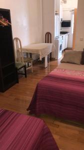 Pokój z 2 łóżkami i stołem oraz kuchnią w obiekcie Apartamentos pandiellos I w Madrycie