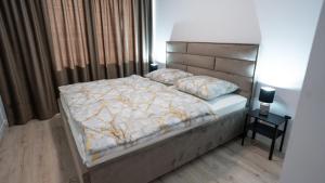 un dormitorio con una cama con cabecero en Downtown28 apartment, en Poprad