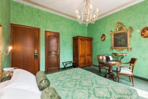 a bedroom with green walls and a bed and a table at Hotel Marconi in Venice