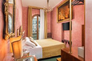 a bedroom with pink walls and a bed and a mirror at Hotel Marconi in Venice