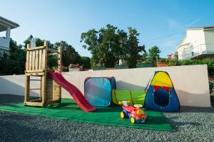 een speeltuin met een glijbaan en een speelgoedauto op een tapijt bij Holiday Home Trend in Donji Zagon