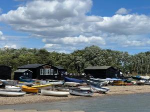 a bunch of boats are sitting on the shore at Cosy 2 bed cottage in beautiful Orford in Orford