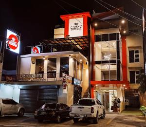 two cars parked in front of a building at night at Emmie Hotel in Legazpi +37 photos