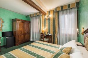 a bedroom with green walls and a bed and a desk at Hotel Marconi in Venice