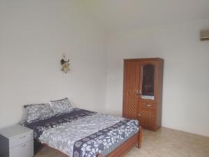 a bedroom with a bed and a wooden cabinet at Bamboo guest house in Quatre Bornes