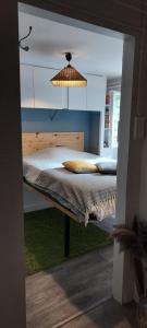 a bedroom with a bed with a light above it at Chambre indépendante chez l'habitant avec salle de bain privée in Alençon