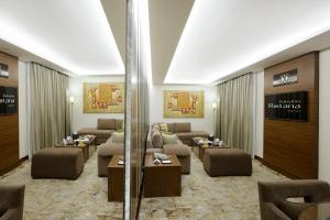 a living room with couches and tables in a room at Babylon Rotana Hotel in Baghdad