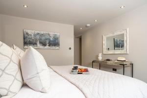 una camera con letto bianco, tavolo e specchio di The Dog House with Hot Tub a Kirkby Lonsdale