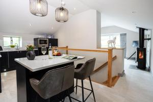una cucina con isola, sedie e piano cottura di The Dog House with Hot Tub a Kirkby Lonsdale
