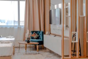 a living room with a blue chair and a tv at Blue Vista Hotel in Dakhla