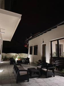 a patio with chairs and tables at night at Apartmani Kolaković in Arandjelovac
