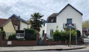 a white house with a palm tree in front of it at Grand gîte 150 m2 - 4 chambres - Salle de jeux avec billard et fléchettes in Péronne