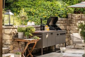 a outdoor kitchen with a stove and a table at Exklusives Ferienhaus in Top Lage mit Pool, Sauna, Terrasse - Der Johannishof in Würzburg