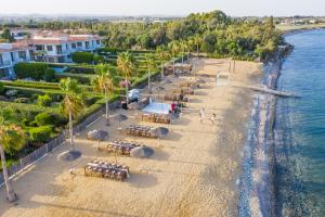 an aerial view of a beach with tables and umbrellas at Atlantis Gardens in Mazotos