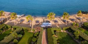 an aerial view of a resort with palm trees and the ocean at Atlantis Gardens in Mazotos