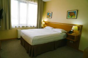 a bedroom with a large bed in a hotel room at City Hotel Bishkek in Bishkek