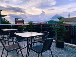 レガスピにあるEmmie Hotelのバルコニーにテーブルと椅子が置かれたパティオ