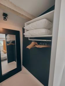 a room with a mirror and shelves with pillows at La Maison l'Oliveraie in Lunel