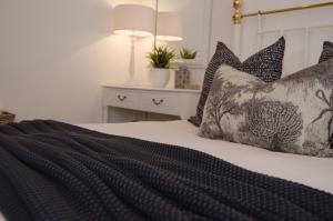a bedroom with a bed with black and white pillows at Killassy House in Graaff-Reinet