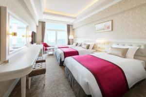 a hotel room with four beds and a window at Takarazuka Hotel in Takarazuka