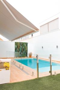a swimming pool in a white building with a white wall at Sunrise & Pool Mairena Metro in Mairena del Aljarafe
