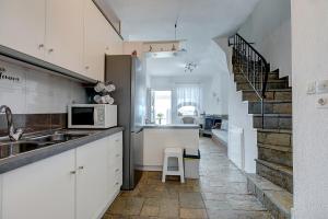 a kitchen with a sink and a kitchen with a staircase at Hemera House Fourka in Fourka