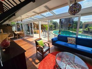a living room with a blue couch and a pool at Lovely House Near Geneva in Prévessin +2 photos